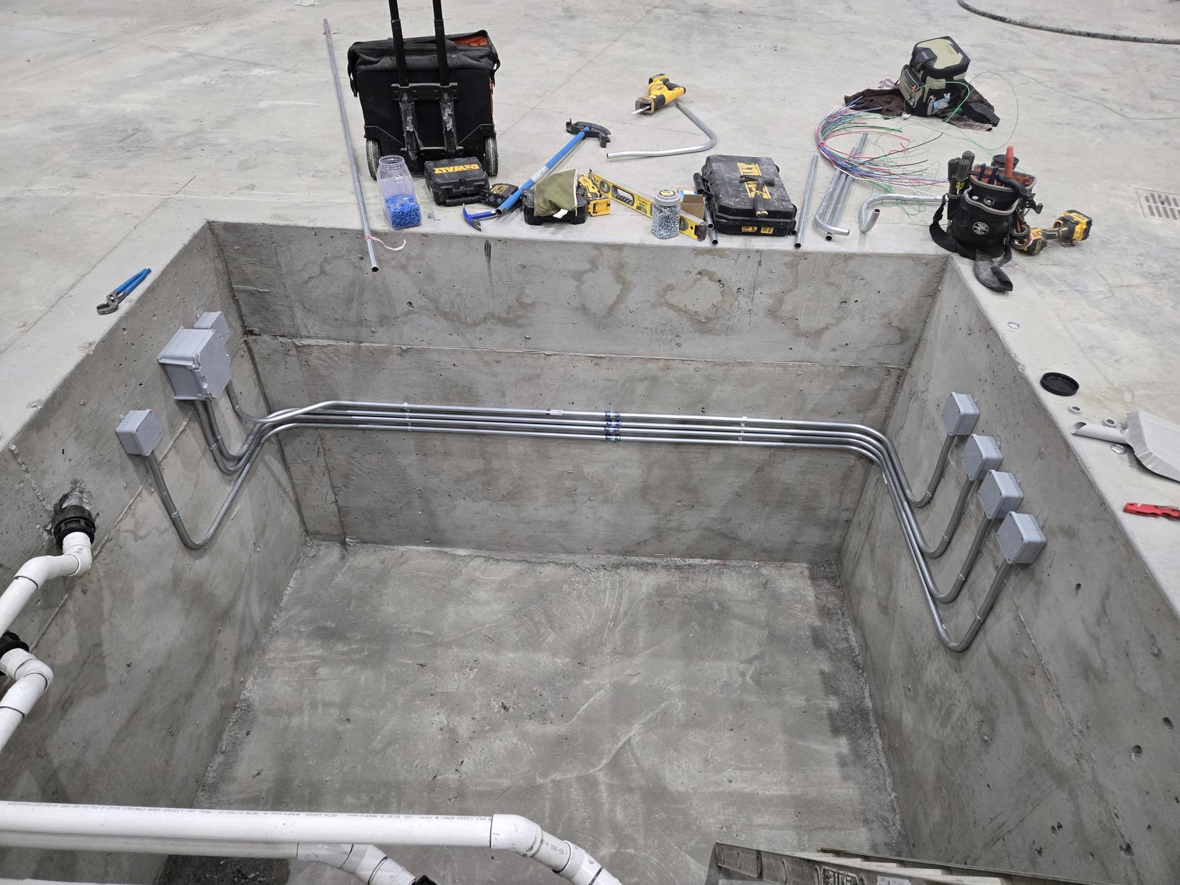 Parallel conduit runs bent and installed in an equipment pit by Hi-Energy Electrical Services