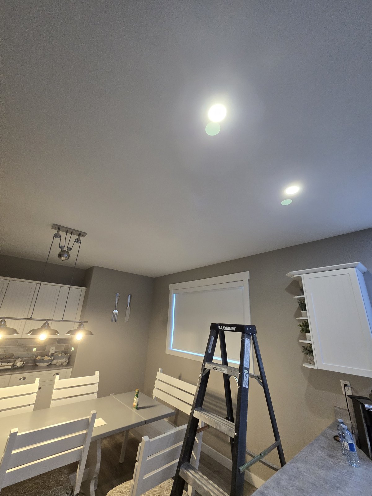Pot lights installed and lit in a dining room by Hi-Energy Electrical Services