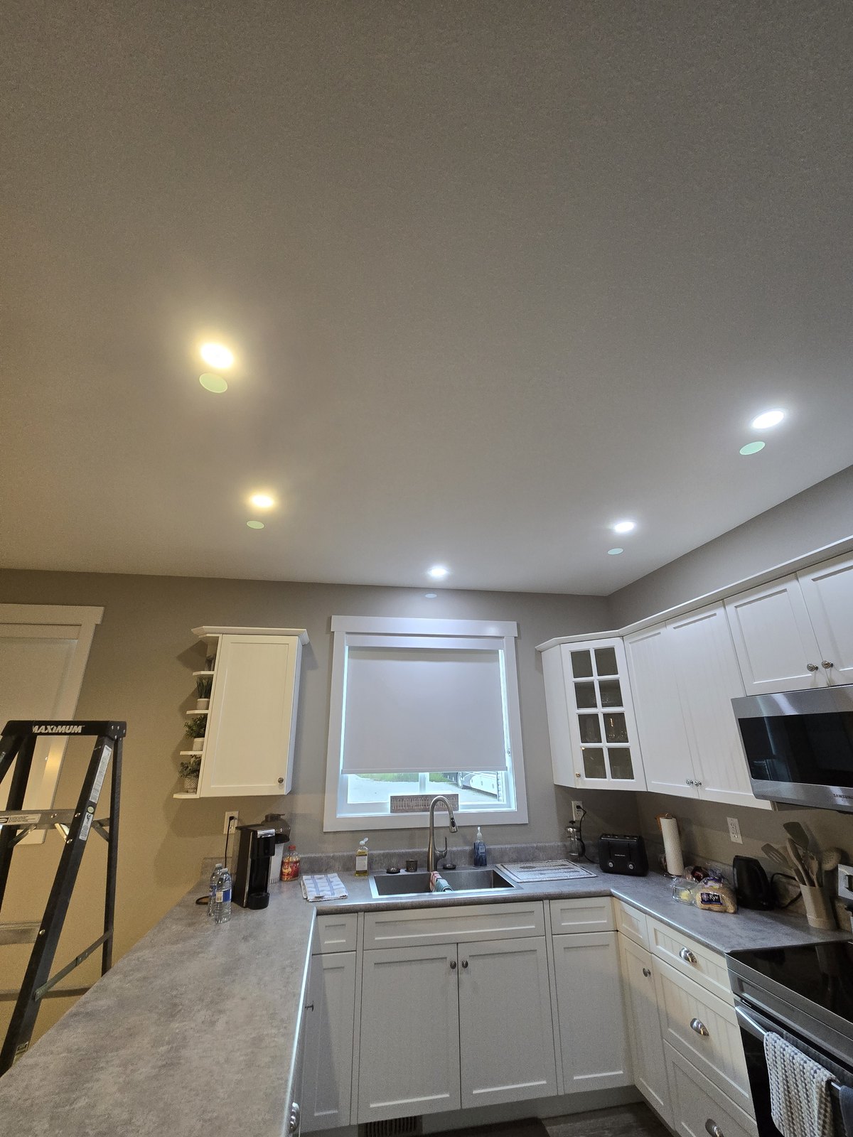 Pot lights installed and lit in a kitchen by Hi-Energy Electrical Services